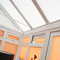 Ginger coloured perfect fit blinds in a conservatory setting.