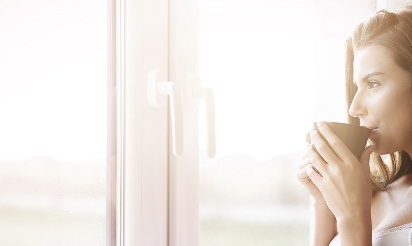 Lady sipping hot chocolate by window