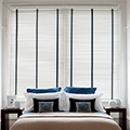 White venetian blinds in a bedroom setting.