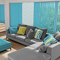 Turquoise coloured vertical blinds in a living room setting.