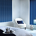 Blue coloured vertical blinds in a bedroom setting.